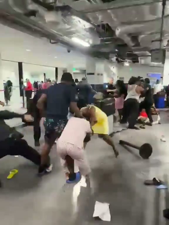 Pasajeros forcejean en el área de aduana de PortMiami tras desembarcar del Carnival Conquest; agentes de CBP intervienen para separar a dos familias
