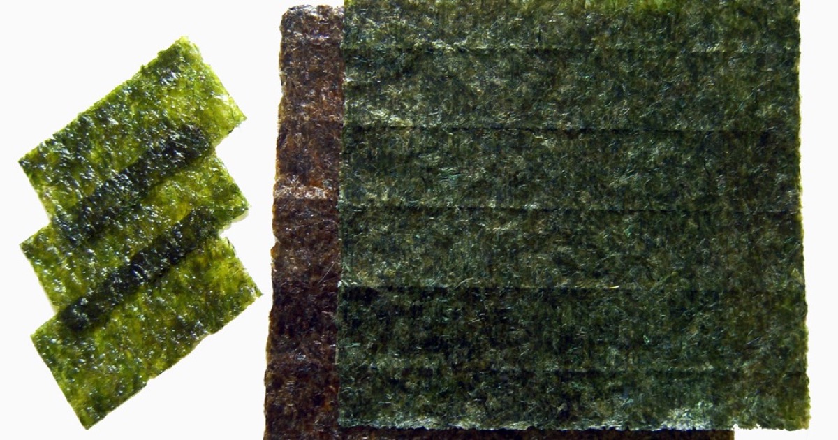 Láminas de alga nori tostada apiladas: snack crujiente de Pyropia yezoensis con color verde oscuro y textura quebradiza