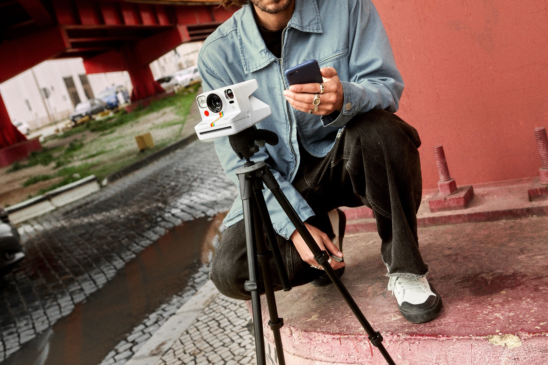 Dos personas en el césped con una Polaroid Go Generation 3 blanca: uso casual de la cámara instantánea más pequeña de Polaroid